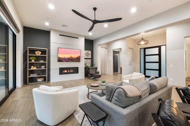 living room with ceiling fan and light hardwood / wood-style floors