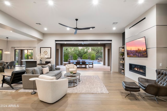 living room with plenty of natural light, light hardwood / wood-style floors, and ceiling fan