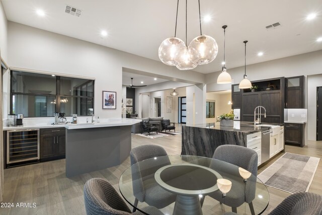 dining area with dark wood-type flooring, beverage cooler, and sink