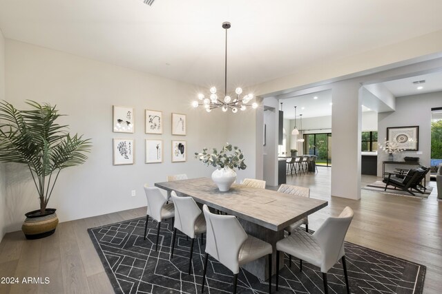 dining room with wood-type flooring and a notable chandelier