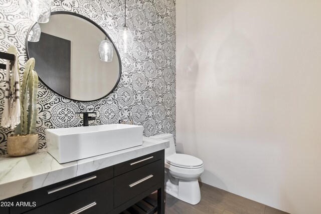 bathroom with vanity, toilet, and hardwood / wood-style floors