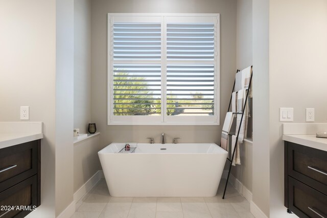 bathroom with vanity, a tub to relax in, and tile patterned flooring