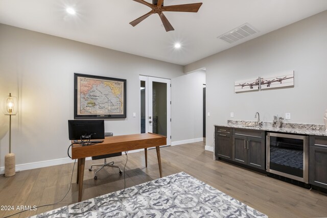 office area featuring ceiling fan, beverage cooler, light hardwood / wood-style floors, and wet bar