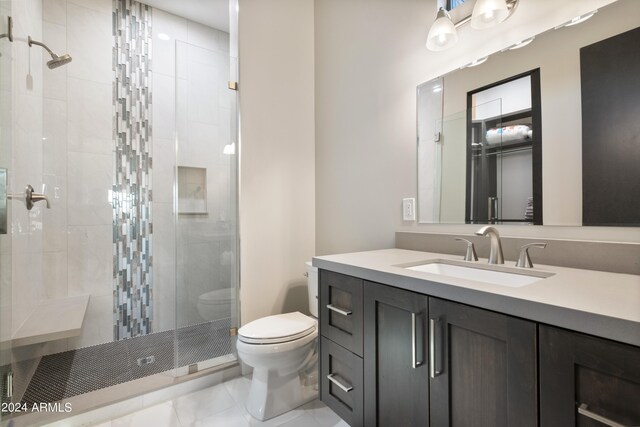 bathroom featuring an enclosed shower, vanity, and toilet