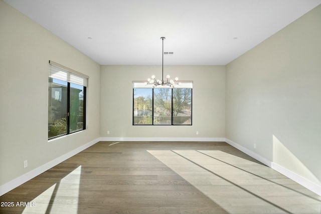 unfurnished dining area featuring hardwood / wood-style flooring, plenty of natural light, and a chandelier