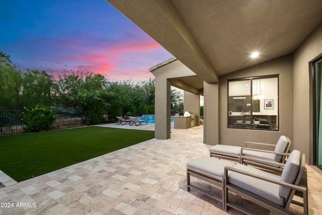 patio terrace at dusk featuring a pool, a yard, and an outdoor living space