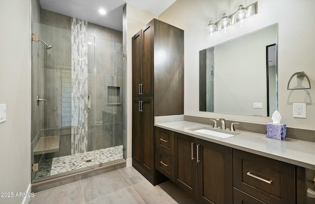 bathroom with walk in shower, vanity, and tile patterned flooring