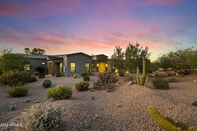 pool at dusk with a patio area, pool water feature, and an outdoor bar