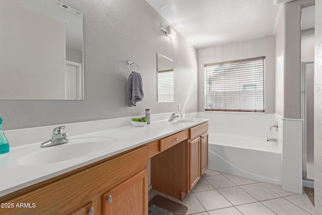 bathroom featuring tile patterned flooring, vanity, and a tub