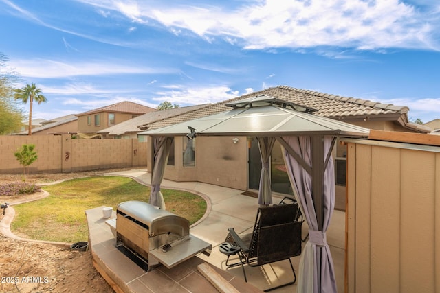 rear view of property with a gazebo, a lawn, and a patio area