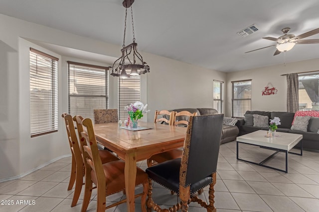 tiled dining space with ceiling fan