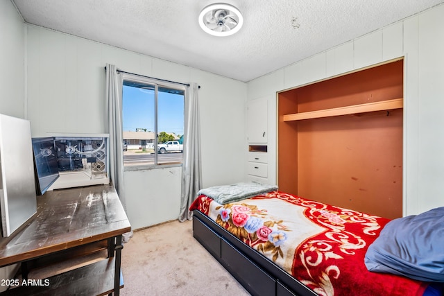 bedroom featuring a textured ceiling and light colored carpet