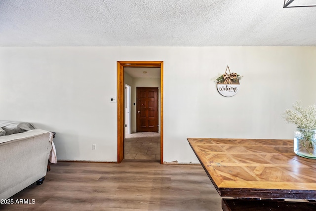dining space featuring wood finished floors and a textured ceiling