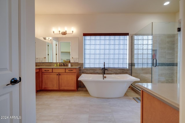 bathroom featuring tile patterned floors, vanity, and shower with separate bathtub