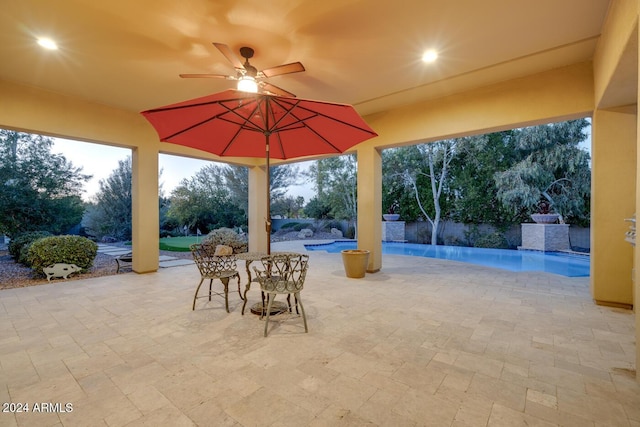 patio terrace at dusk with pool water feature and ceiling fan