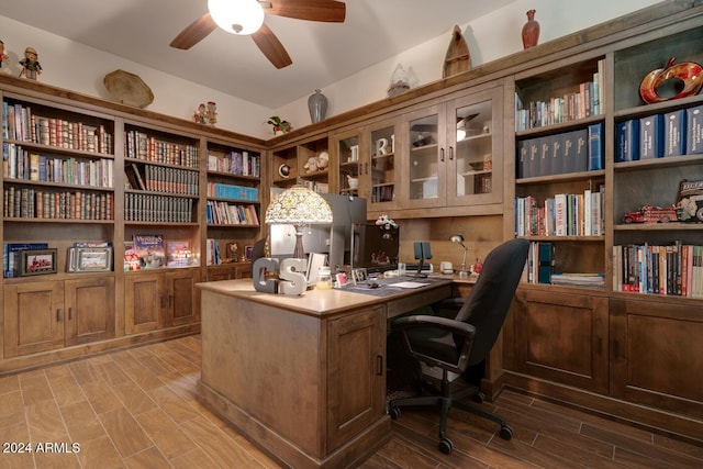 office space featuring ceiling fan and built in desk