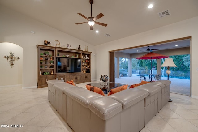 living room with ceiling fan, light tile patterned floors, and lofted ceiling