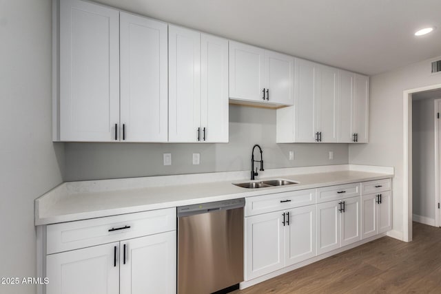 kitchen with light countertops, stainless steel dishwasher, a sink, and white cabinetry