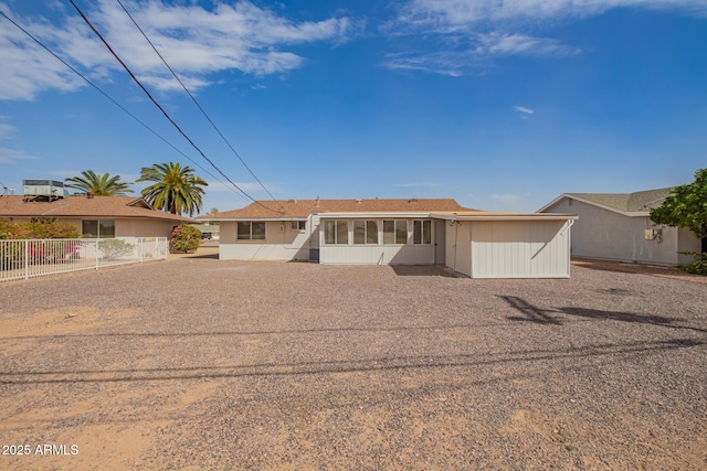 single story home featuring fence and a sunroom