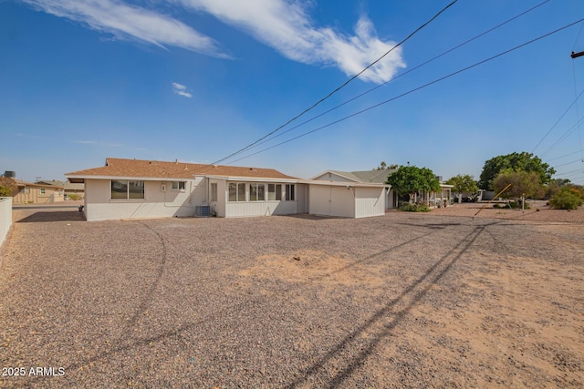 ranch-style home with a sunroom, fence, and central AC unit