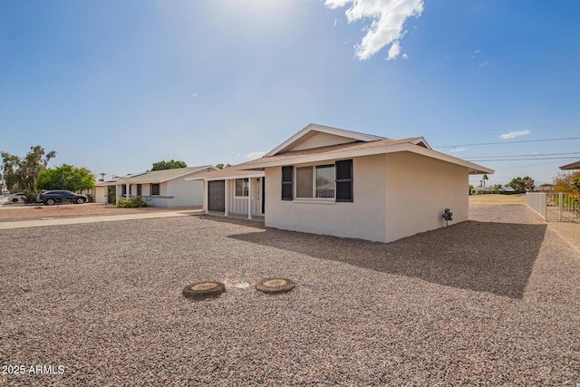 ranch-style house with fence and stucco siding