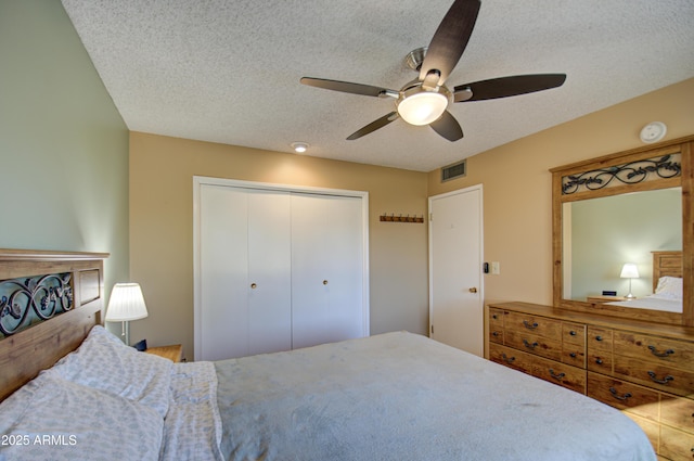 bedroom featuring ceiling fan, a textured ceiling, and a closet