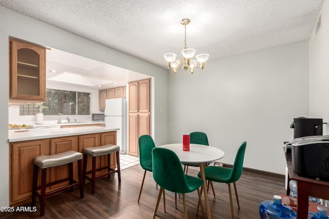 6207 N 21st Dr, Phoenix, AZ 85015 - dining space with dark wood finished floors, visible vents, a chandelier, and a textured ceiling