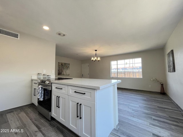 kitchen featuring white cabinetry, electric range, dark hardwood / wood-style floors, and kitchen peninsula