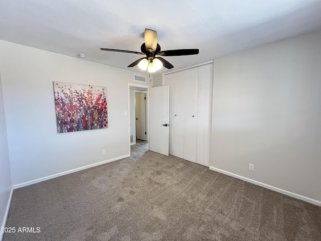 carpeted spare room featuring ceiling fan