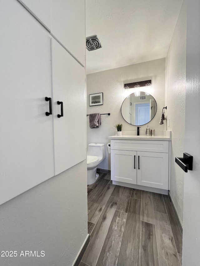 bathroom with vanity, hardwood / wood-style floors, and toilet