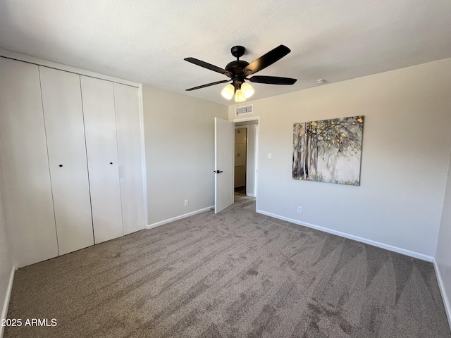 unfurnished bedroom with light carpet, a textured ceiling, ceiling fan, and a closet