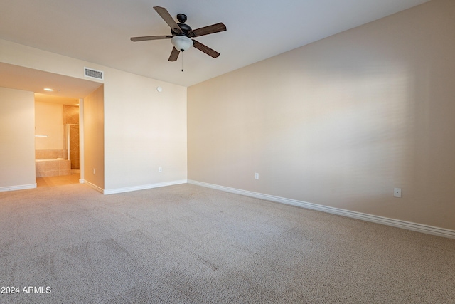 empty room featuring ceiling fan and carpet