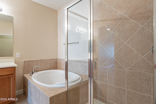 bathroom featuring tile patterned flooring, shower with separate bathtub, and vanity