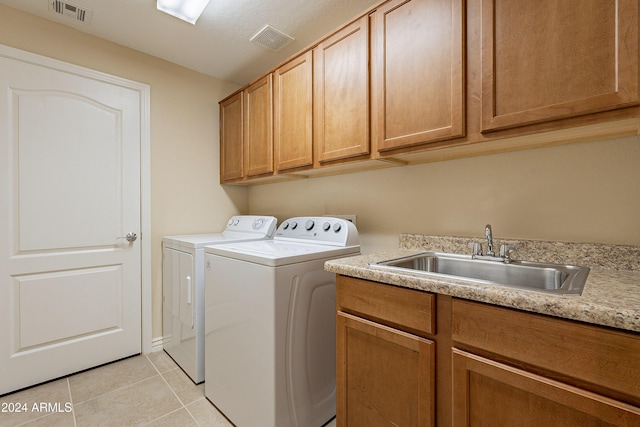 washroom with separate washer and dryer, sink, light tile patterned floors, and cabinets