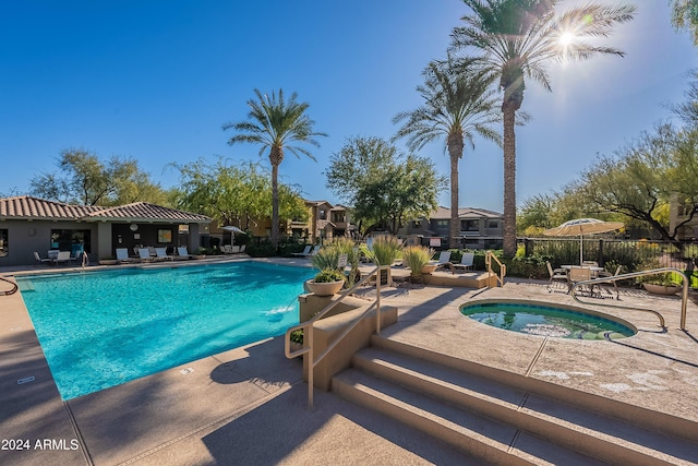 view of swimming pool featuring a community hot tub and a patio