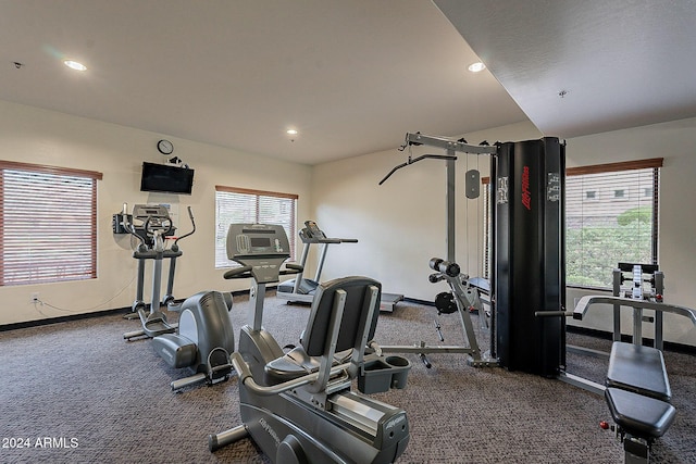 gym featuring plenty of natural light and dark carpet