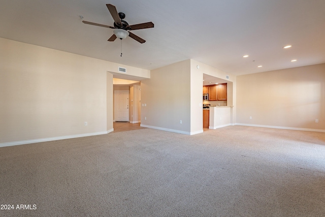 unfurnished living room with light carpet and ceiling fan