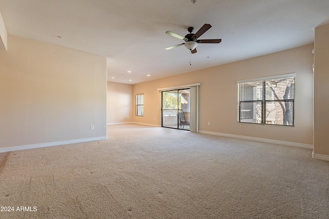 empty room with ceiling fan and light carpet