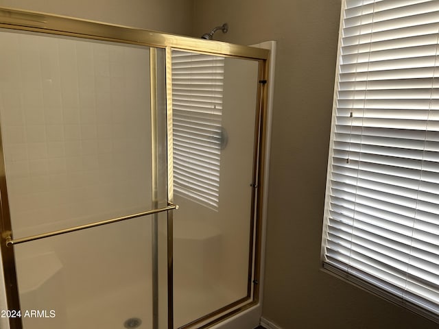 bathroom with a shower with door