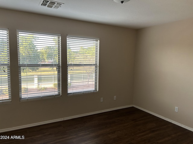 unfurnished room with dark wood-type flooring