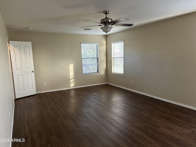 spare room featuring ceiling fan and dark wood-type flooring