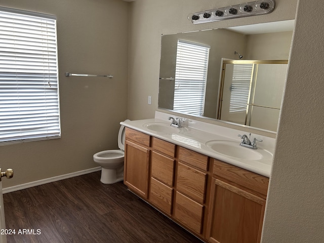 bathroom with hardwood / wood-style floors, vanity, toilet, and walk in shower