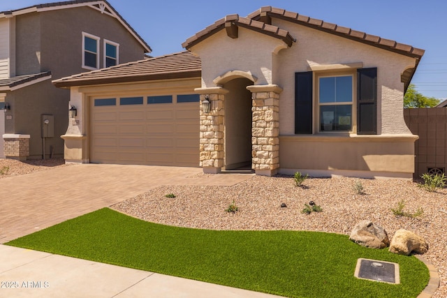 15788 W Georgia Dr W, Surprise, AZ 85379 - view of front of property with decorative driveway, a garage, a tiled roof, stone siding, and stucco siding