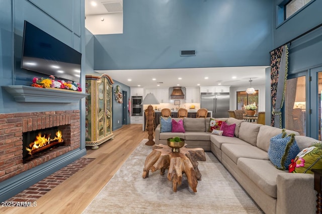 8219 S Pecan Grove Cir, Tempe, AZ 85284 - living room with a high ceiling, a fireplace, light wood-style floors, and recessed lighting