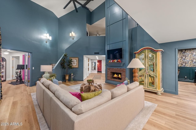 8219 S Pecan Grove Cir, Tempe, AZ 85284 - living area featuring high vaulted ceiling, light wood finished floors, a brick fireplace, ceiling fan, and baseboards