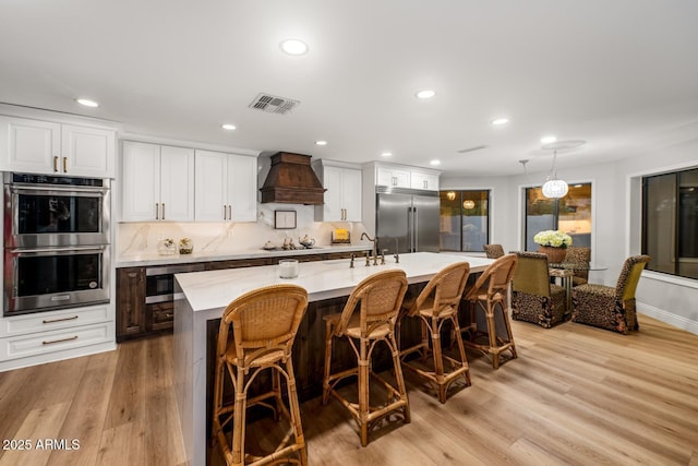 8219 S Pecan Grove Cir, Tempe, AZ 85284 - kitchen with stainless steel appliances, custom range hood, light countertops, recessed lighting, and decorative backsplash