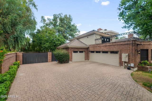 8219 S Pecan Grove Cir, Tempe, AZ 85284 - view of front of house with a gate, an attached garage, decorative driveway, and a balcony