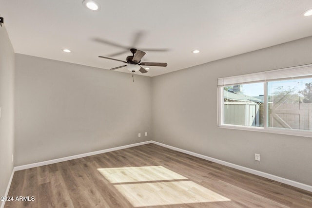 spare room featuring baseboards, wood finished floors, and recessed lighting