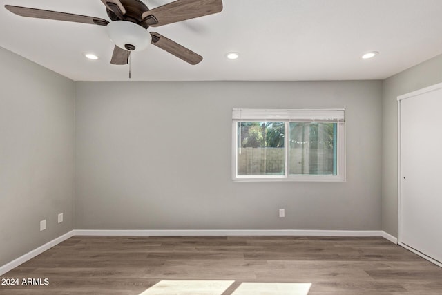 empty room with recessed lighting, baseboards, and wood finished floors