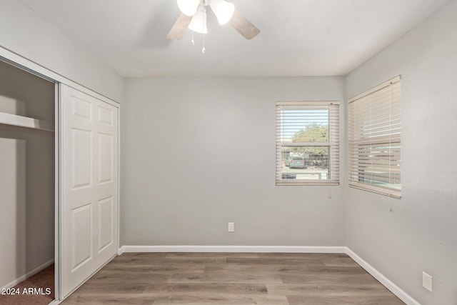 unfurnished bedroom featuring wood finished floors, a ceiling fan, and baseboards